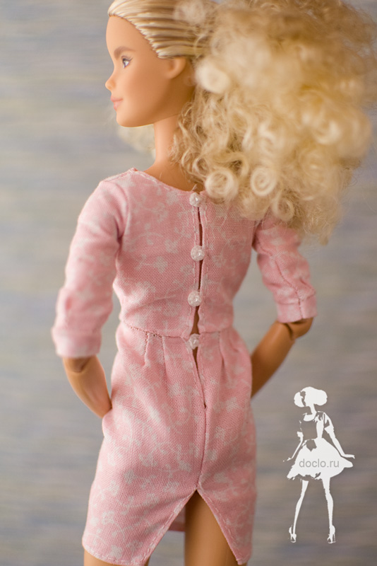 Увеличенная фотография куклы барби в коротком платье с драпировкой, вид сзади